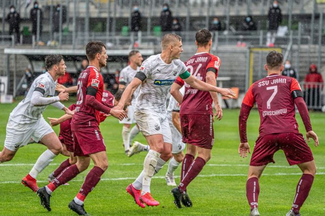 На фото: защитник «Зандхаузена» Александр Жиров (в центре в белой форме) с капитанской повязкой в матче 27-го тура второй Бундеслиги против «Регенсбурга» (0:0).