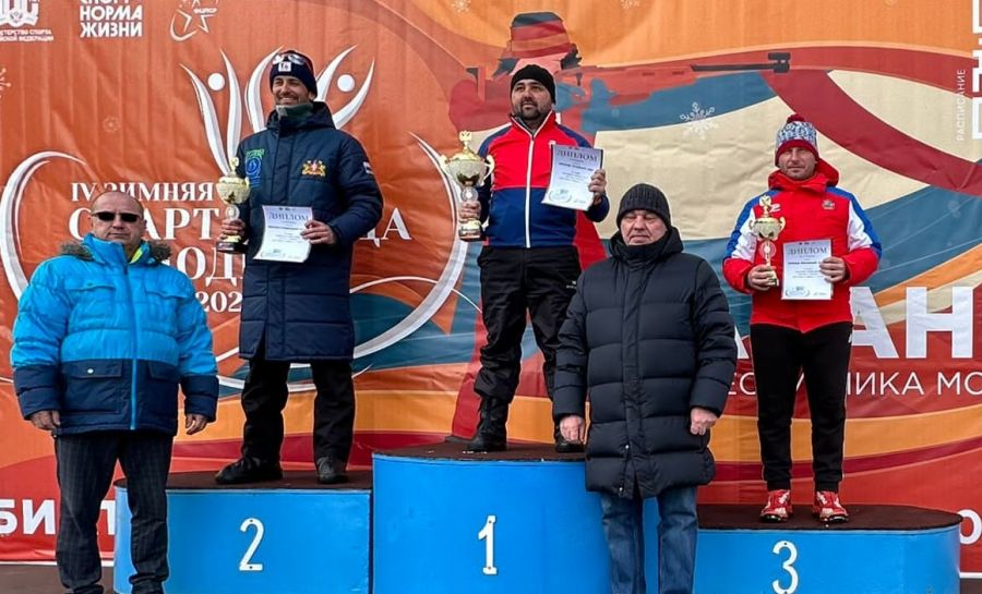 Тренер АУОР Станислав Базеев на первой ступени пьедестала с кубком за победу в командном зачете по биатлону Спартакиады молодежи России-2023