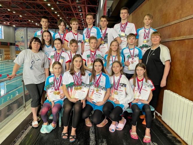 Елена Скороход (слева) и Елена Чубаева (справа) с пловцами — победителями и призёрами соревнований. Фото: СШ «Дельфин»
