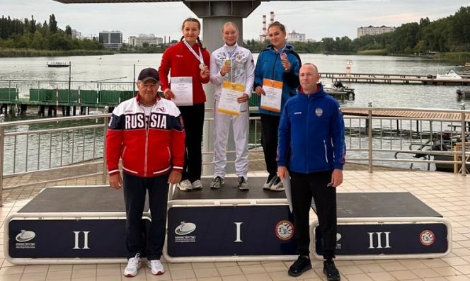 Пьедестал в каноэ на дистанции 500 м среди юниорок до 19 лет. Справа тренер Александры Власовой Михаил Волков